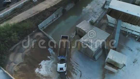 在水泥厂上空高空钻卡车装载和浇筑沙子建筑工业用地视频的预览图