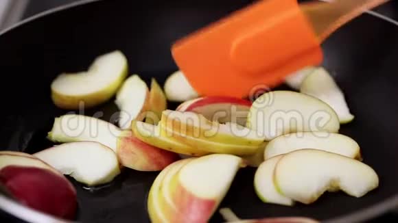 在平底锅中煎苹果用铲子搅拌黄油起泡沸腾自制蛋糕视频的预览图