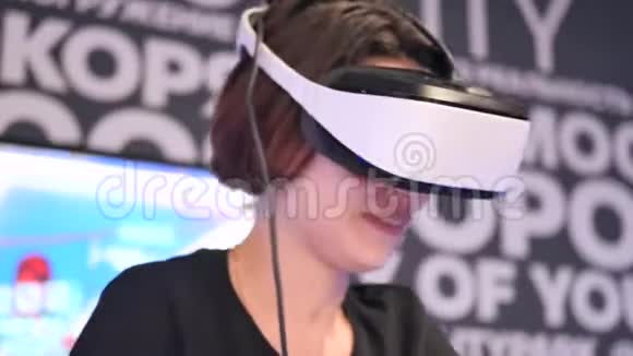 一个年轻的黑发女孩在虚拟现实俱乐部骑自行车摘下虚拟现实眼镜惊讶的情绪视频的预览图
