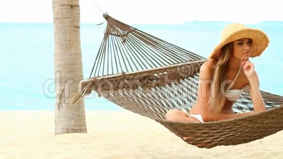 异国风情海滩吊床上的快乐女人视频的预览图