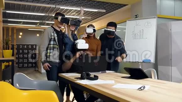 年轻的商业团队在VR虚拟现实眼镜中寻找笔记本电脑并开始庆祝成功的交易视频的预览图