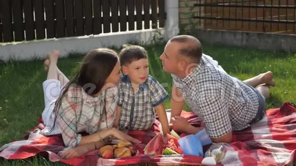 英俊的父亲和年轻的母亲亲吻可爱的小男孩视频的预览图