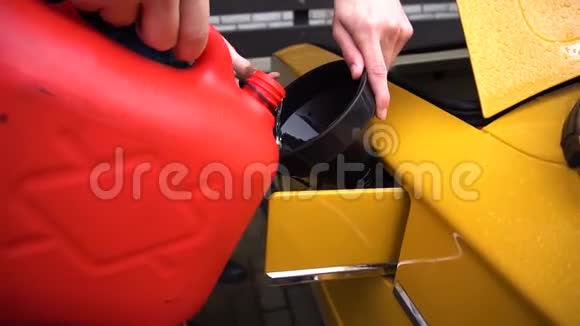 男人或男人用红色的罐子给石油黄色的车加油视频的预览图