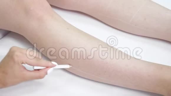 治疗师的手在美容院访客的腿上画线条视频的预览图