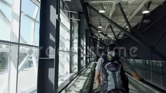 带背包的年轻人用机场走道沿着大厅去坐飞机视频的预览图