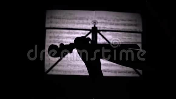 手指在背景片中用音符演奏小提琴的弦快关门后景剪影视频的预览图