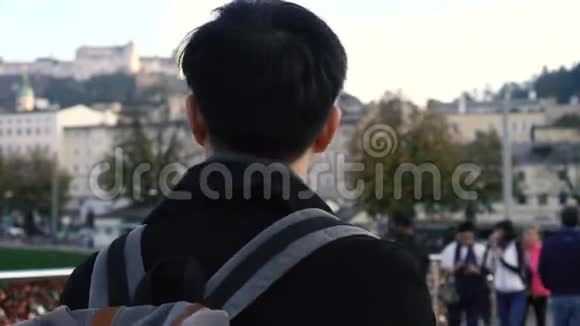年轻的亚洲旅行背包客在欧洲市中心在奥地利萨尔茨堡的大街上散步的人视频的预览图