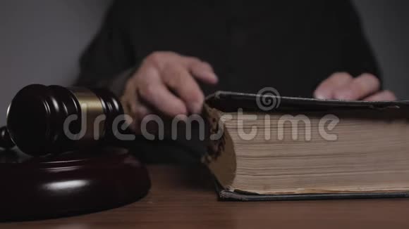 正义与法律的概念在法庭工作的法官翻翻一本旧书视频的预览图