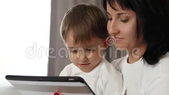 家庭肖像母子俩带着情绪看着平板电脑的屏幕快乐快乐有趣视频的预览图