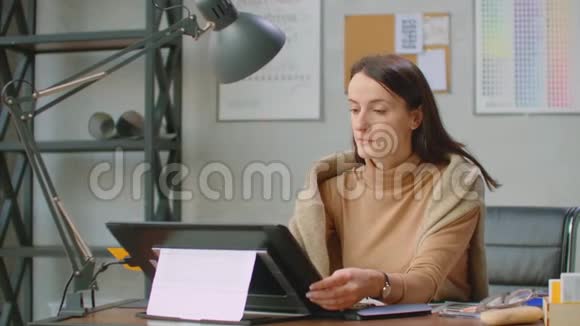 女平面设计师手工使用互动笔显示数字绘图平板和笔在电脑上在办公室视频的预览图