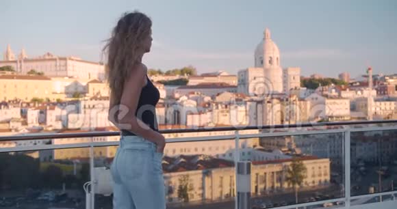 幸福的女人走在阳台上可以看到葡萄牙里斯本的城市视频的预览图