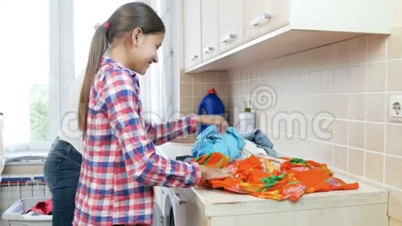 4k镜头可爱的女孩在洗衣店帮妈妈整理和折叠衣服视频的预览图