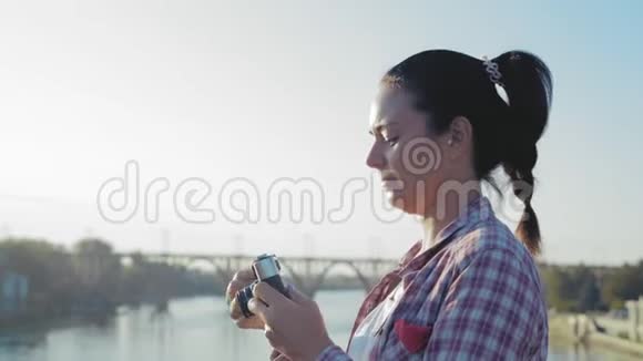 特写镜头美丽的女人站在桥上拍电影视频的预览图