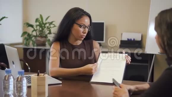 非裔美国律师向成熟的女性客户提交合同视频的预览图