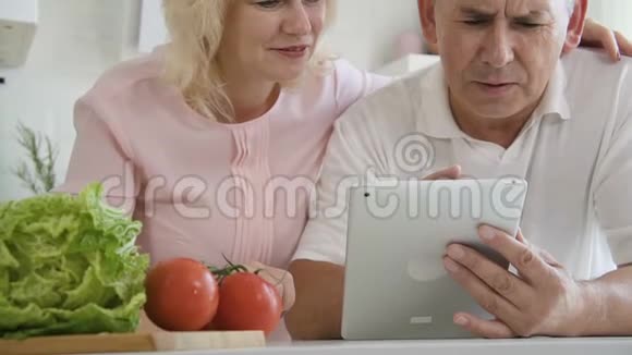 成熟的已婚夫妇正在学习使用平板电脑视频的预览图