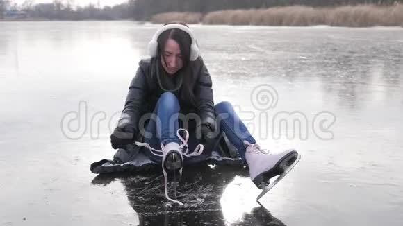 穿着手套的女孩在溜冰场系鞋带视频的预览图