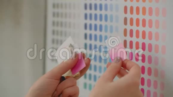 年轻的女色彩设计师站在墙边挑选颜色看素描花墙视频的预览图