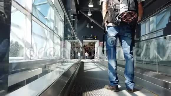 一个背着背包的年轻人的特写镜头使用机场走道穿过机场坐在飞机上视频的预览图
