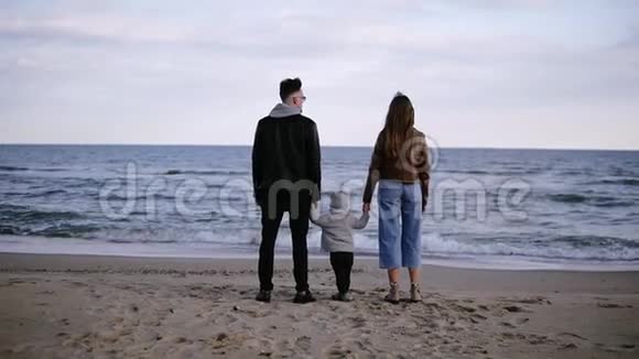 美丽的缓慢的动作场景年轻的老式的夫妇他们的孩子站在大海前看着视频的预览图