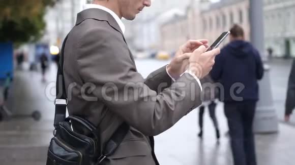 在街上使用触摸手机的商人视频的预览图