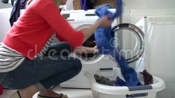 女人把衣服装进洗衣机视频的预览图