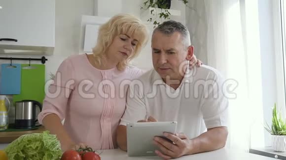 成熟的女人解释高级丈夫如何使用平板电脑视频的预览图