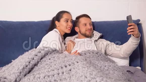 快乐的一对夫妇躺在床上做自拍视频的预览图