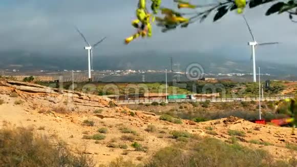 风车涡轮发电机在高速公路附近有很多汽车来往绿色树木植物视频的预览图