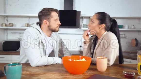 男人和女人一边吃爆米花一边讨论新鲜新闻视频的预览图