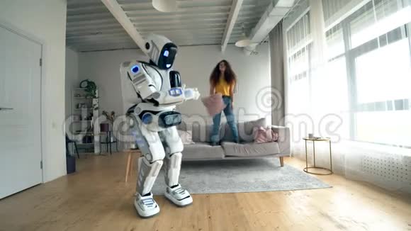快乐的女孩和一个机器人在一个房间里一起跳舞机器人半机器人和人类概念视频的预览图