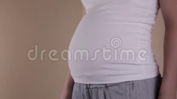 特写腹部孕妇做摇滚符号在家抱着肚子怀孕母亲观念婴儿淋浴器视频的预览图