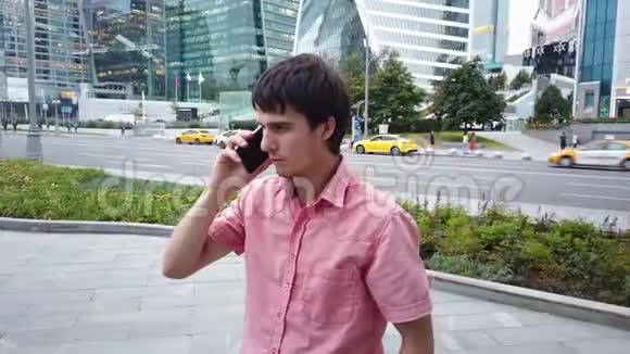 有魅力的年轻人站在市中心讲手机视频的预览图