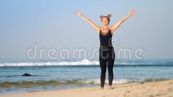 美丽的头发女人在海边练习呼吸瑜伽视频的预览图