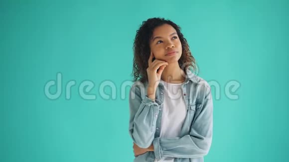 美丽的非洲裔美国妇女在蓝色背景下做梦的肖像视频的预览图