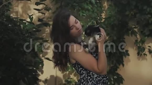 夏天年轻漂亮的女人在花园里抚摸和亲吻小毛兔特写视频的预览图