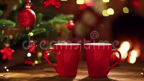壁炉背景上的圣诞装饰品和红杯咖啡视频的预览图