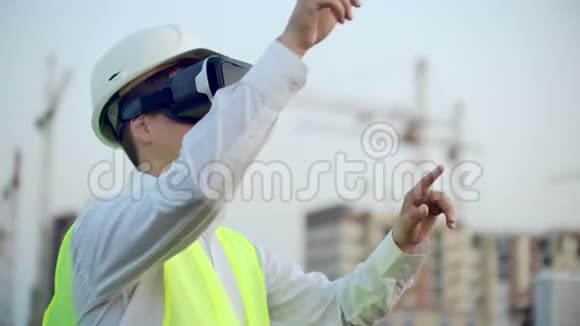 一名男性起重机操作员使用虚拟现实眼镜操作施工现场的肖像建筑经理视频的预览图