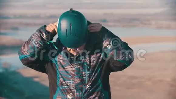 滑雪板一名男子滑雪板工人戴上头盔视频的预览图