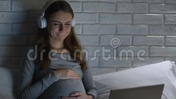 带着耳机哭着让孕妇在笔记本电脑上看剧情片视频的预览图