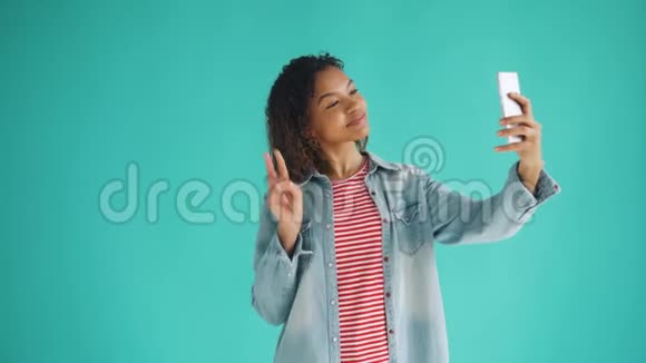 迷人的非裔美国女孩用智能手机相机自拍的肖像视频的预览图