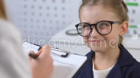 戴眼镜的女学生微笑着看眼科医生开处方视频的预览图