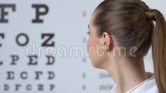 微笑漂亮的眼科医生检查病人的视力指向眼睛测试图视频的预览图