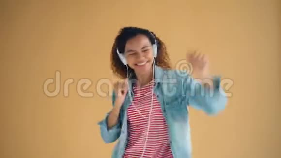 可爱的非裔美国女士用耳机听音乐跳舞的肖像视频的预览图
