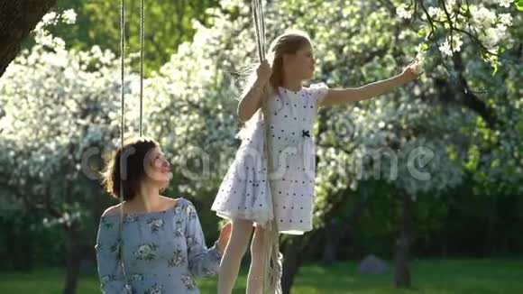 快乐的女儿女孩摘苹果树开花把它放进妈妈的头发里静态视频的预览图