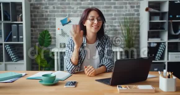 漂亮的女孩在办公室里翘着嘴说着看着手提电脑屏幕在工作中打手势视频的预览图