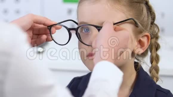 快乐的女孩戴上医生开的眼镜照镜子健康视频的预览图