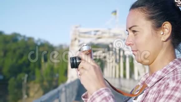 特写镜头美丽的女人在桥上的倒车镜头上拍照视频的预览图