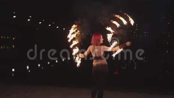 夜间放火时女性在燃烧着的扇子视频的预览图