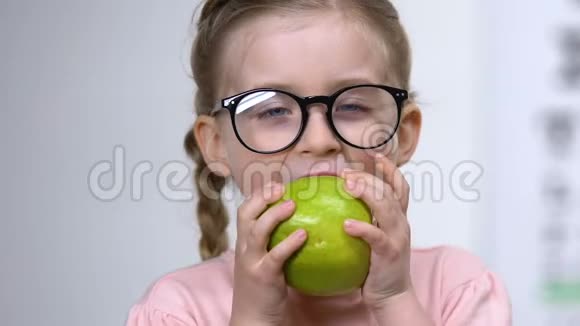 微笑小女孩眼镜吃绿苹果健康营养维生素视频的预览图