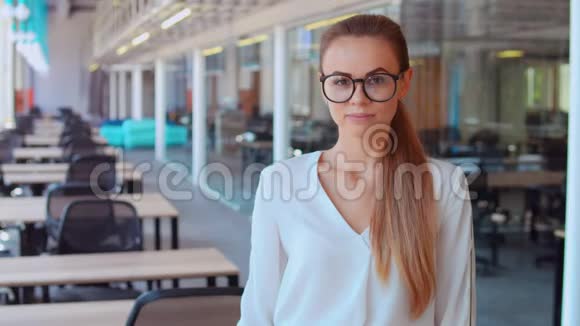在工作场所戴眼镜的女商人显示视频的预览图